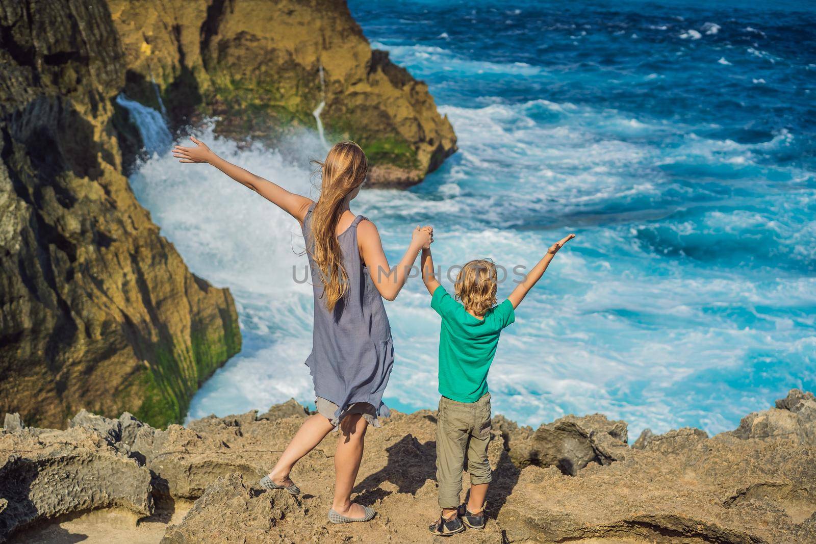 mother and son tourists against the background of the sea Angel's Billabong in Nusa Penida, Bali, Indonesia. Travel to Bali with kids concept by galitskaya