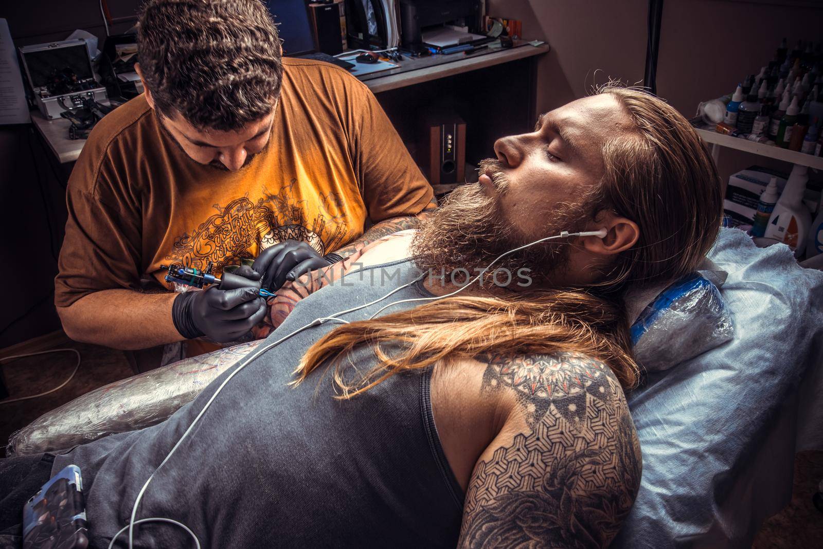 Tattoo master at work in tattoo studio by Proff