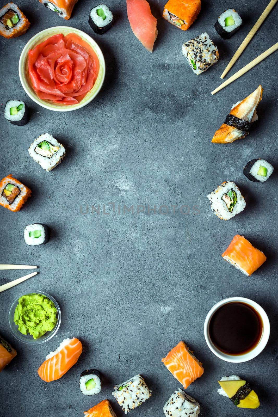 Japanese sushi on a dark background. Sushi rolls, nigiri, maki, pickled ginger, wasabi, soy sauce. Sushi set on a table. Space for text. Top view. Sushi background. Asian or Japanese food frame. Toned