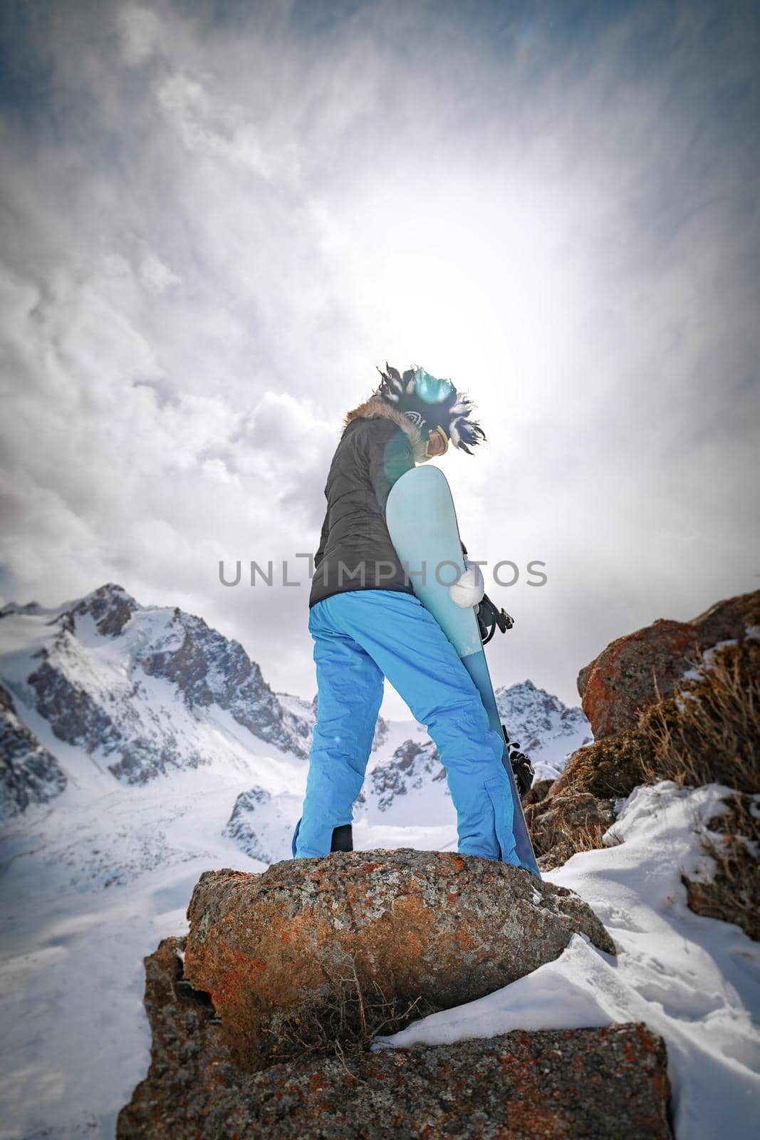 Back view snowboarder in high mountain. Copy space