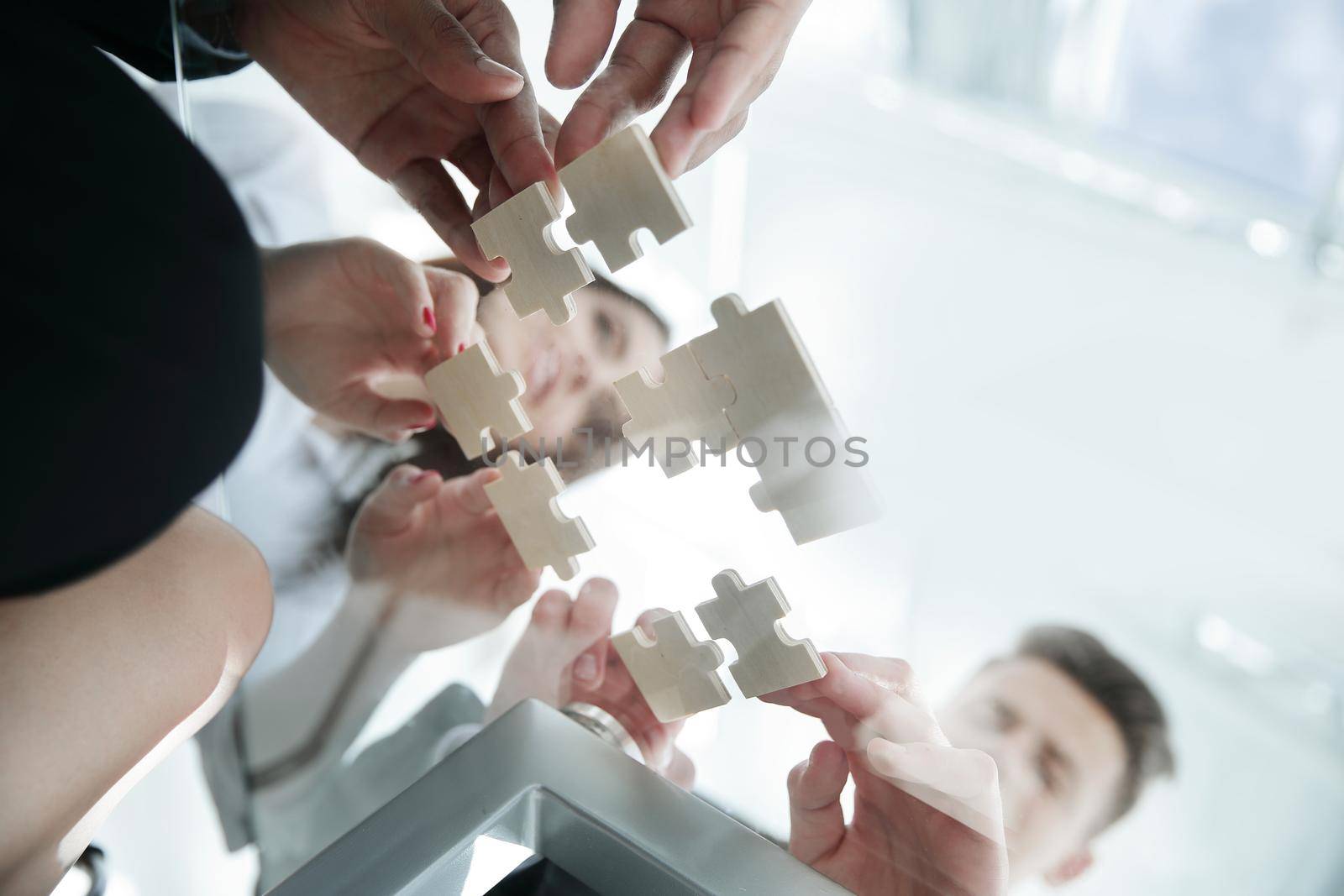 bottom view. business team folding puzzle pieces. .concept business solutions