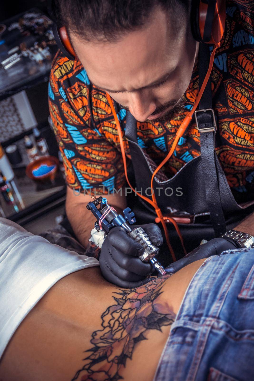 Tattooist create tattoo in tattoo studio./Tattoo specialist makes tattoo in studio.