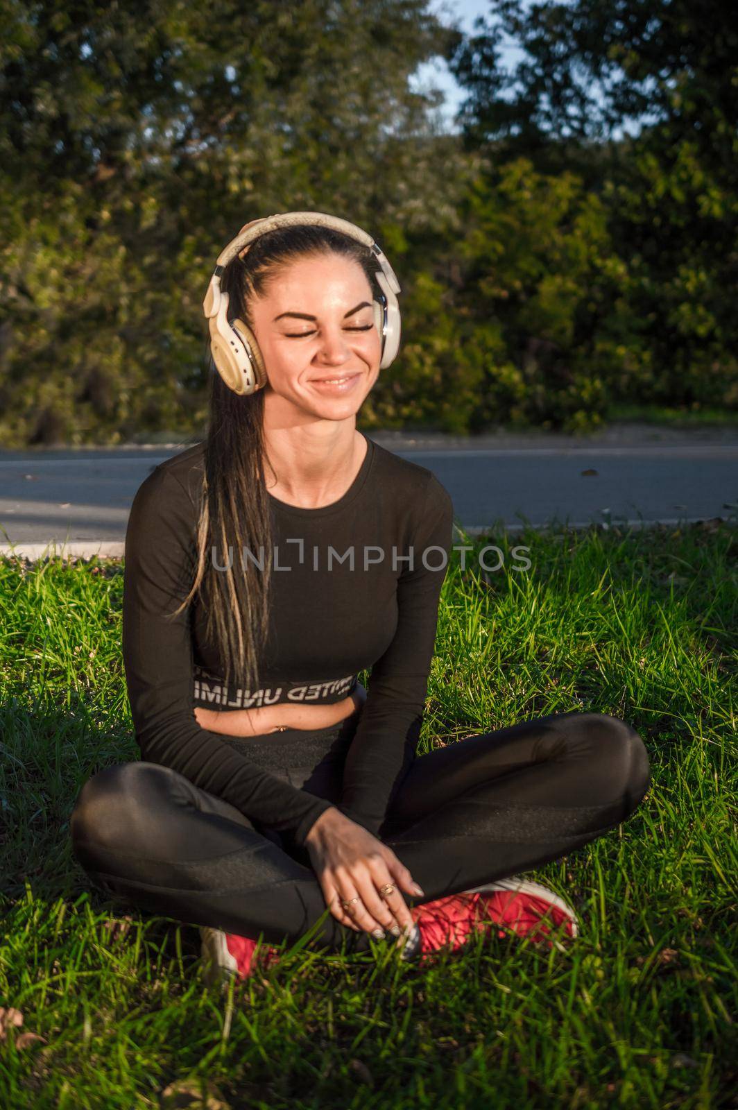 Fit girl listening to the music with headphones./Athletic girl listens to music .