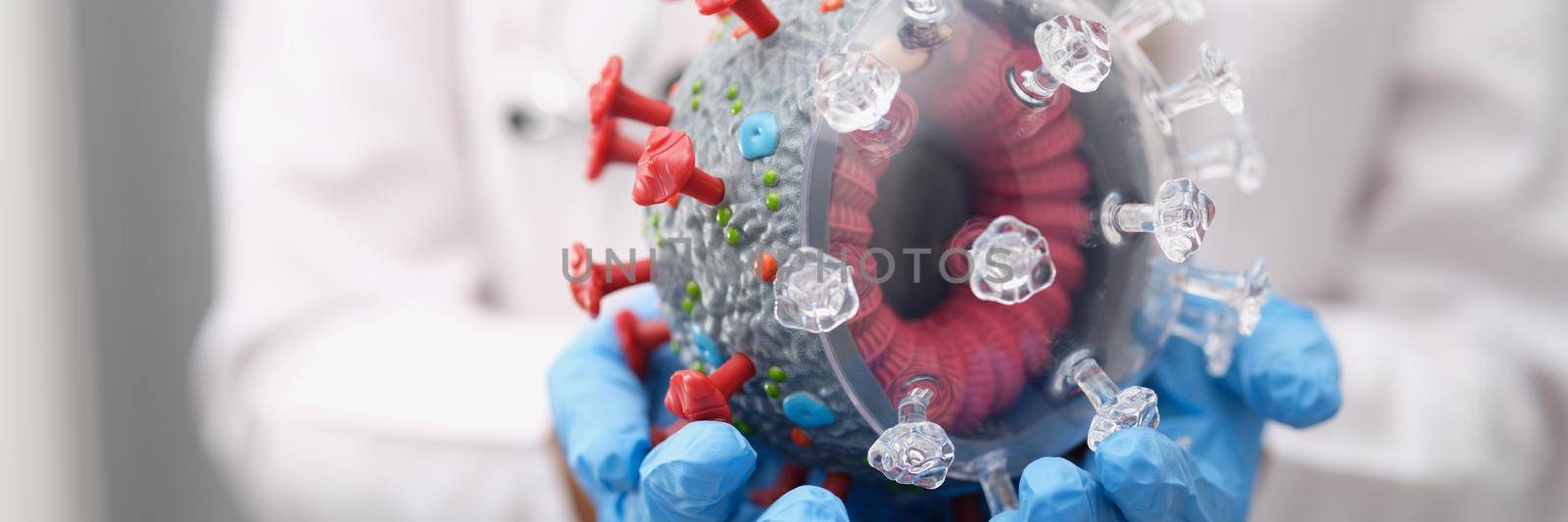 Doctor holding a mock up of coronavirus, close-up by kuprevich