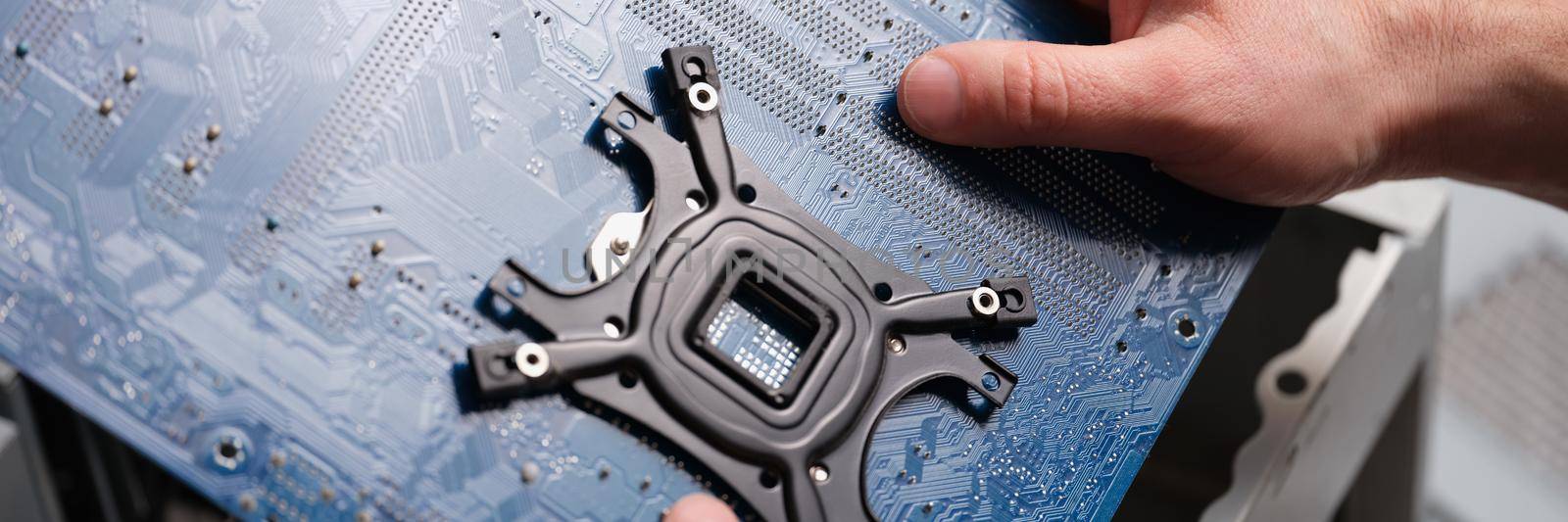 A man holds a motherboard over a pc, close-up by kuprevich