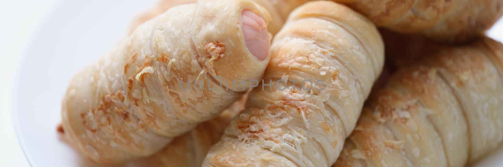 Sausage dough on a plate, culinary product, close-up. Snack for students and schoolchildren. Pigs in a blanket