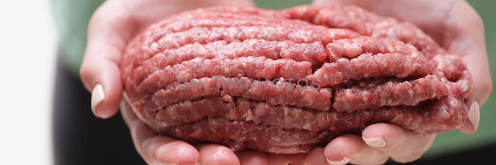 Female hands hold fresh minced meat, close-up by kuprevich