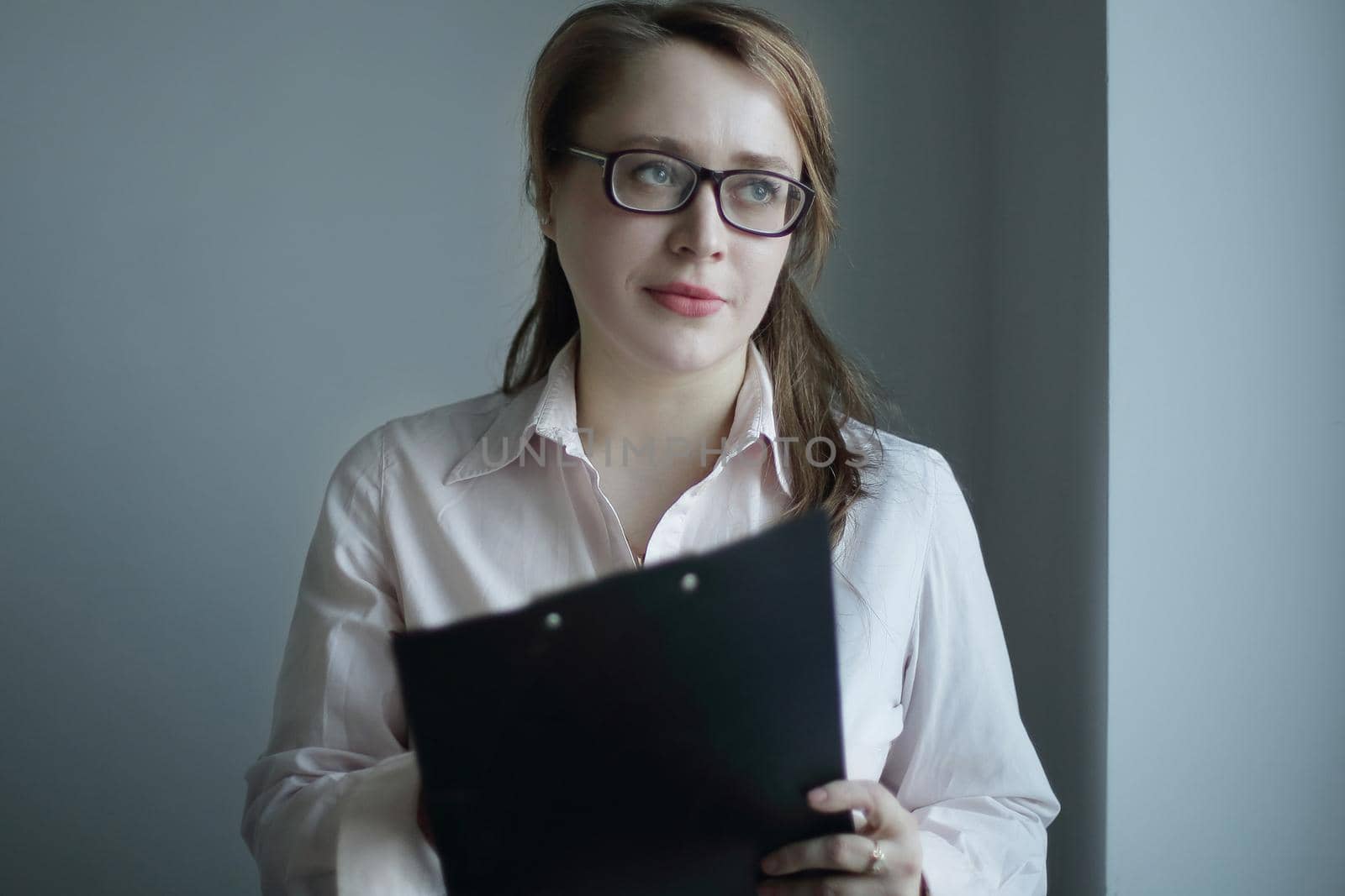 business woman reading a business document.isolated on grey background