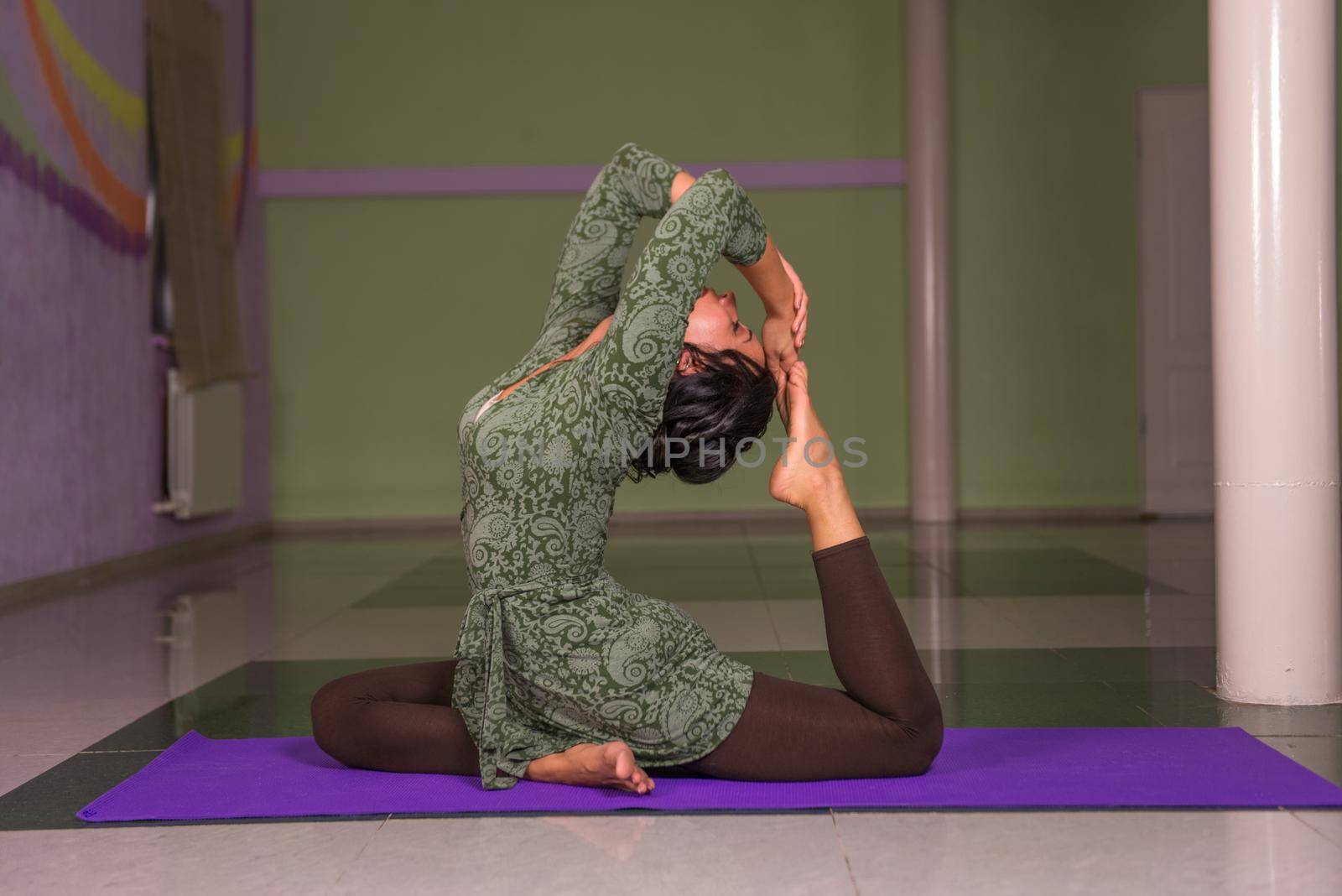 Fit girl stretching ./Yoga trainee teaches yoga lesson in a studio.