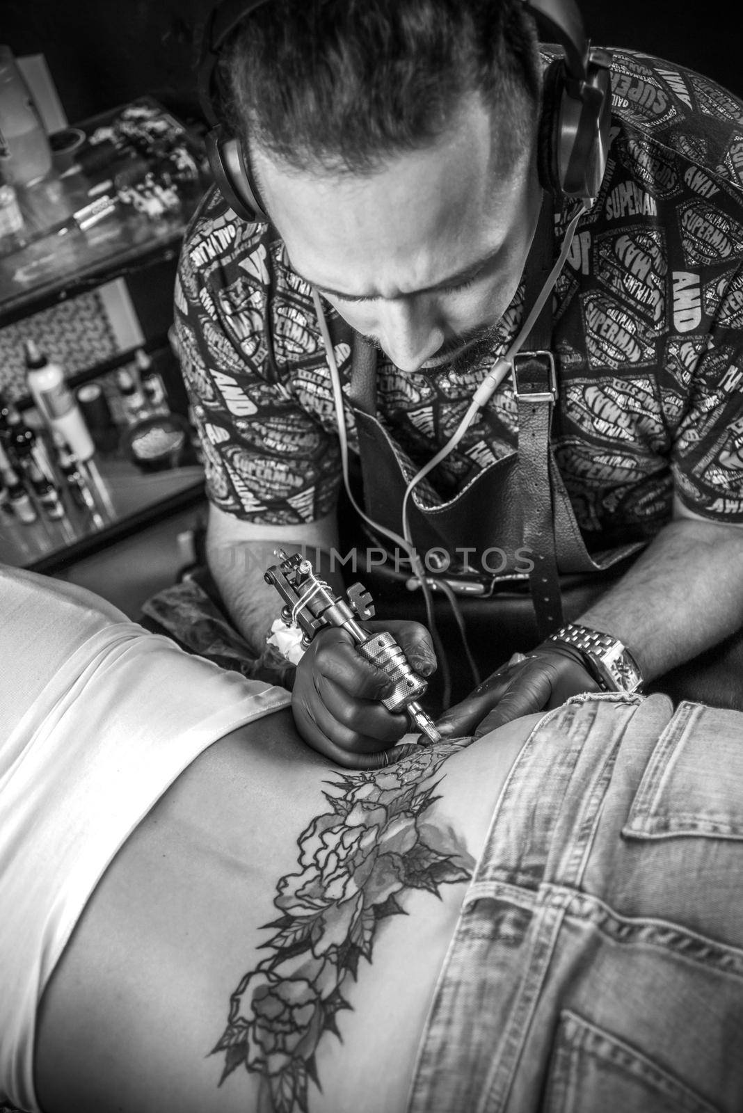 Master tattooist at work in tattoo parlor./Tattooist doing tattoo picture in tatoo salon.