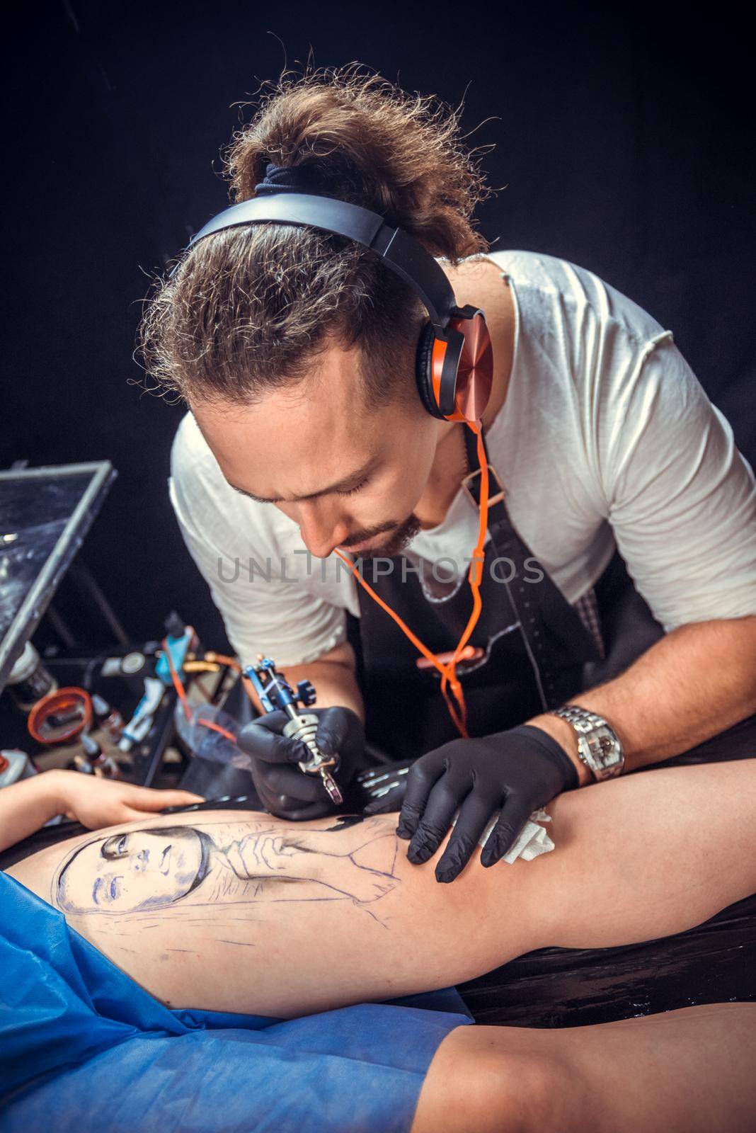 Tattoo specialist working tattooing in tattoo studio.