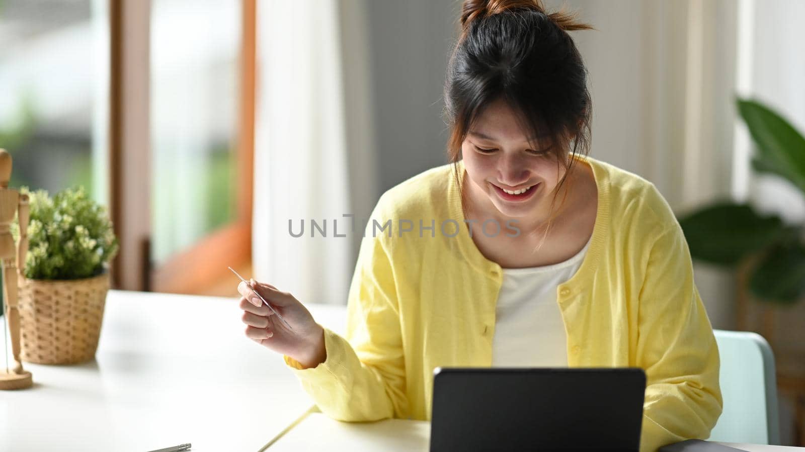 Happy asian woman shopping online, using internet banking service on computer tablet.