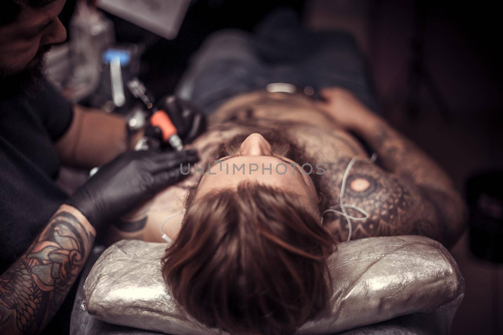 Professional tattooist shows the process of tattooing tattoo studio.