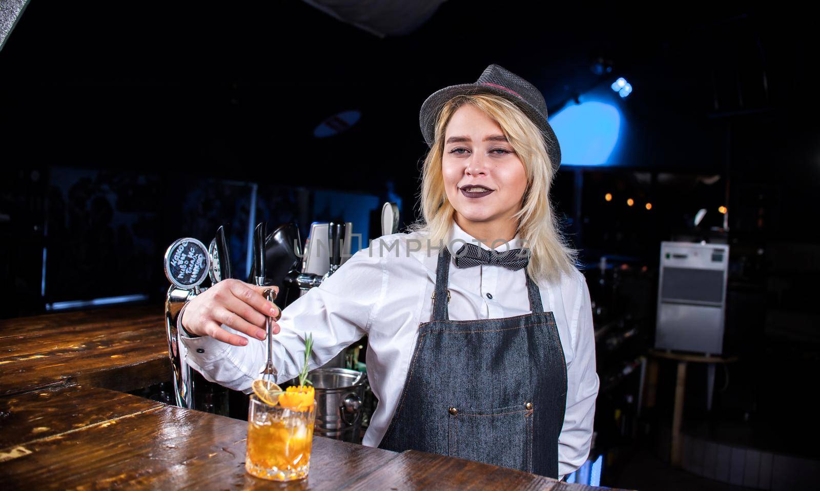 Girl bartender concocts a cocktail on the bar