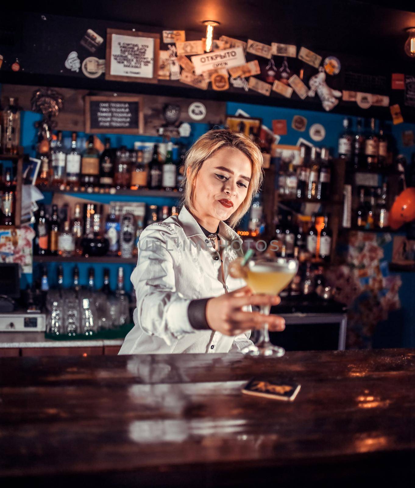 Professional girl barman makes a show creating a cocktail in the nightclub