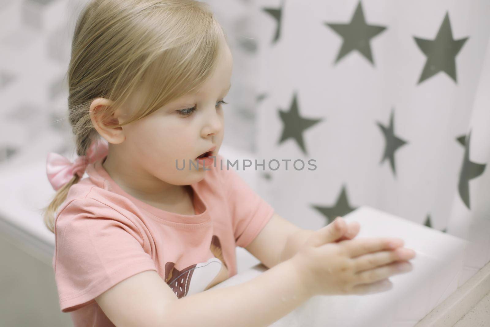 Little toddler girl in bathroom washing hands. Cute sweet baby play in water. Healthy, Child Hygiene concept.