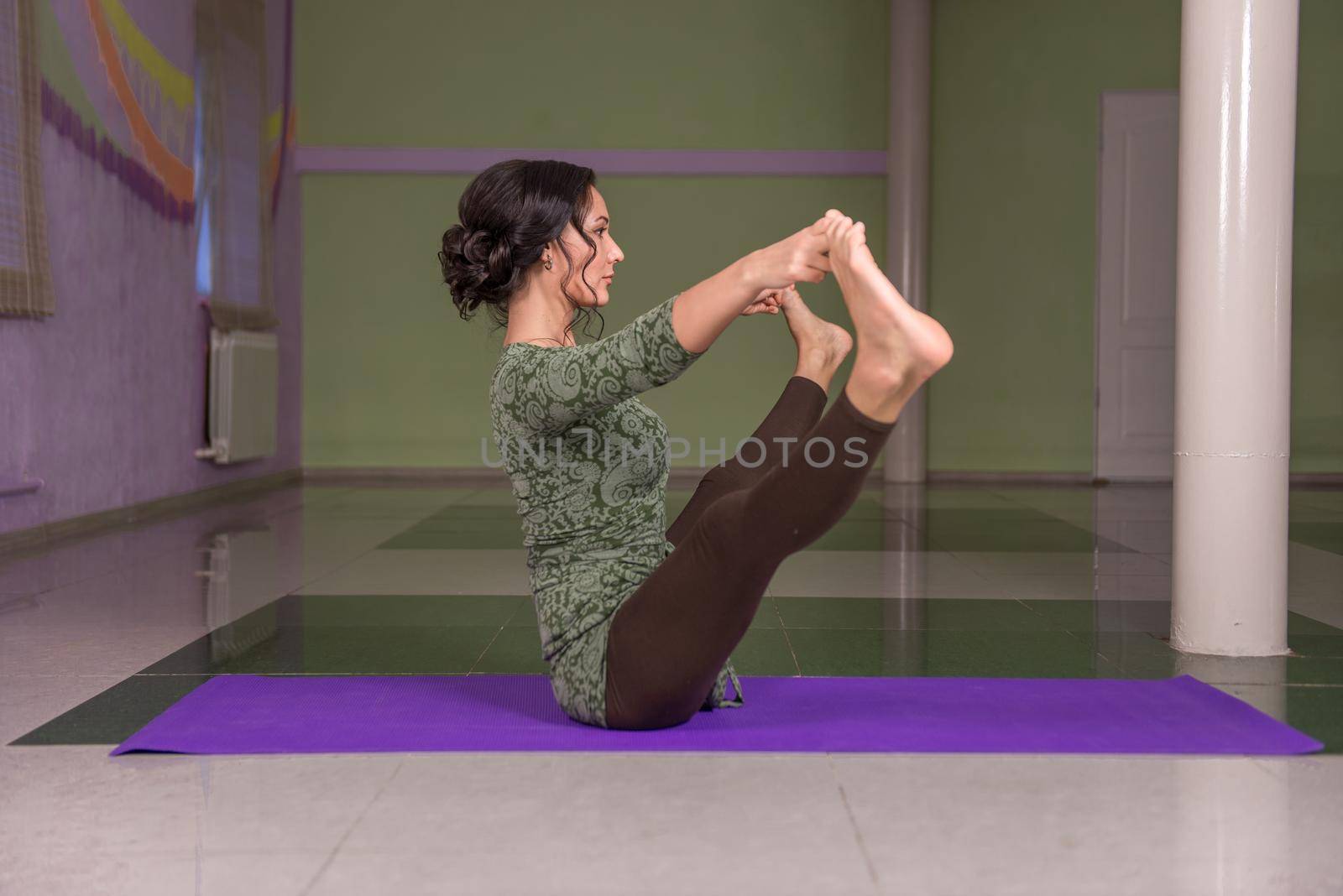 Professional yoga trainer practices yoga lesson in the gym./Yogi teaches yoga lesson in a studio.