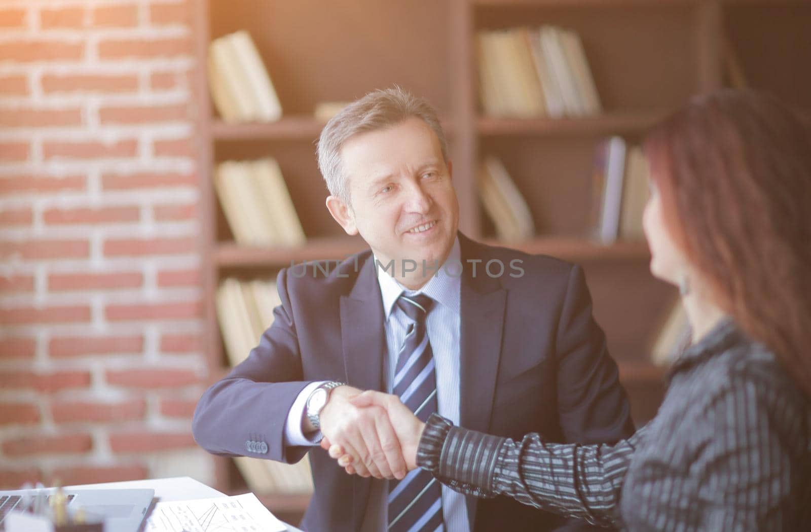 handshake business partners near the desktop in the office.the partnership concept