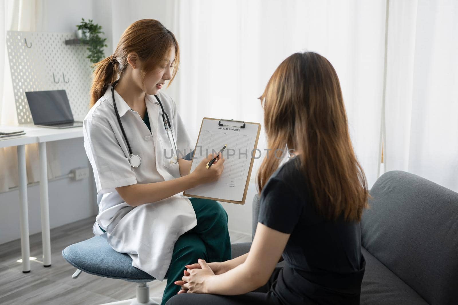 Focused female doctor in white uniform giving professional consultation to patient. Healthcare and medical concept.