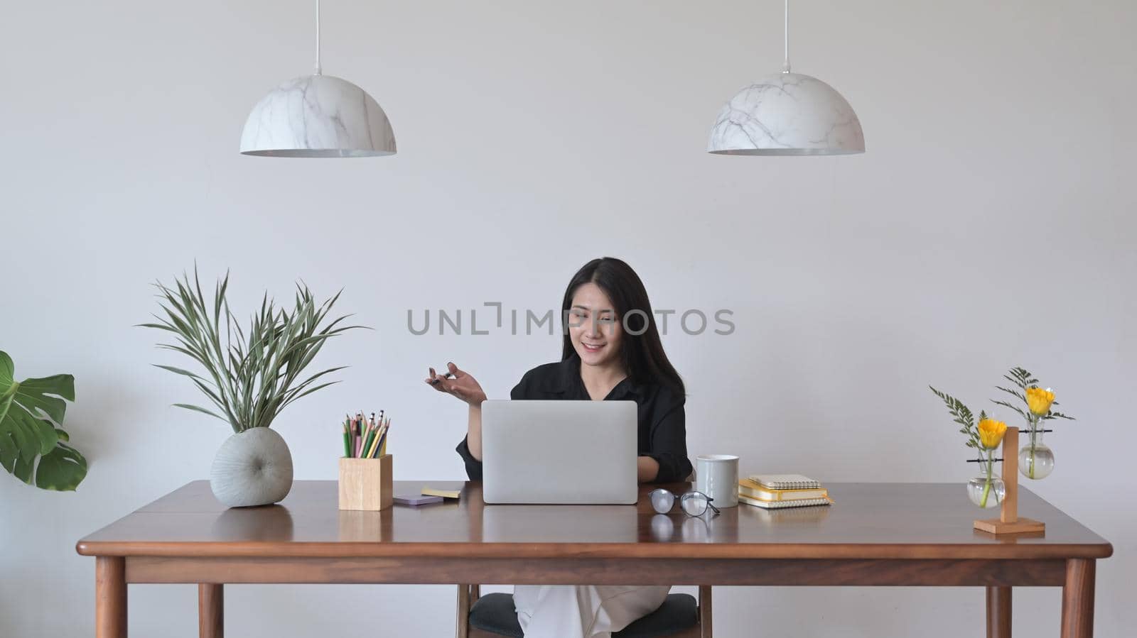 Young business woman having video conference meeting with colleagues, looking at laptop computer screen. by prathanchorruangsak