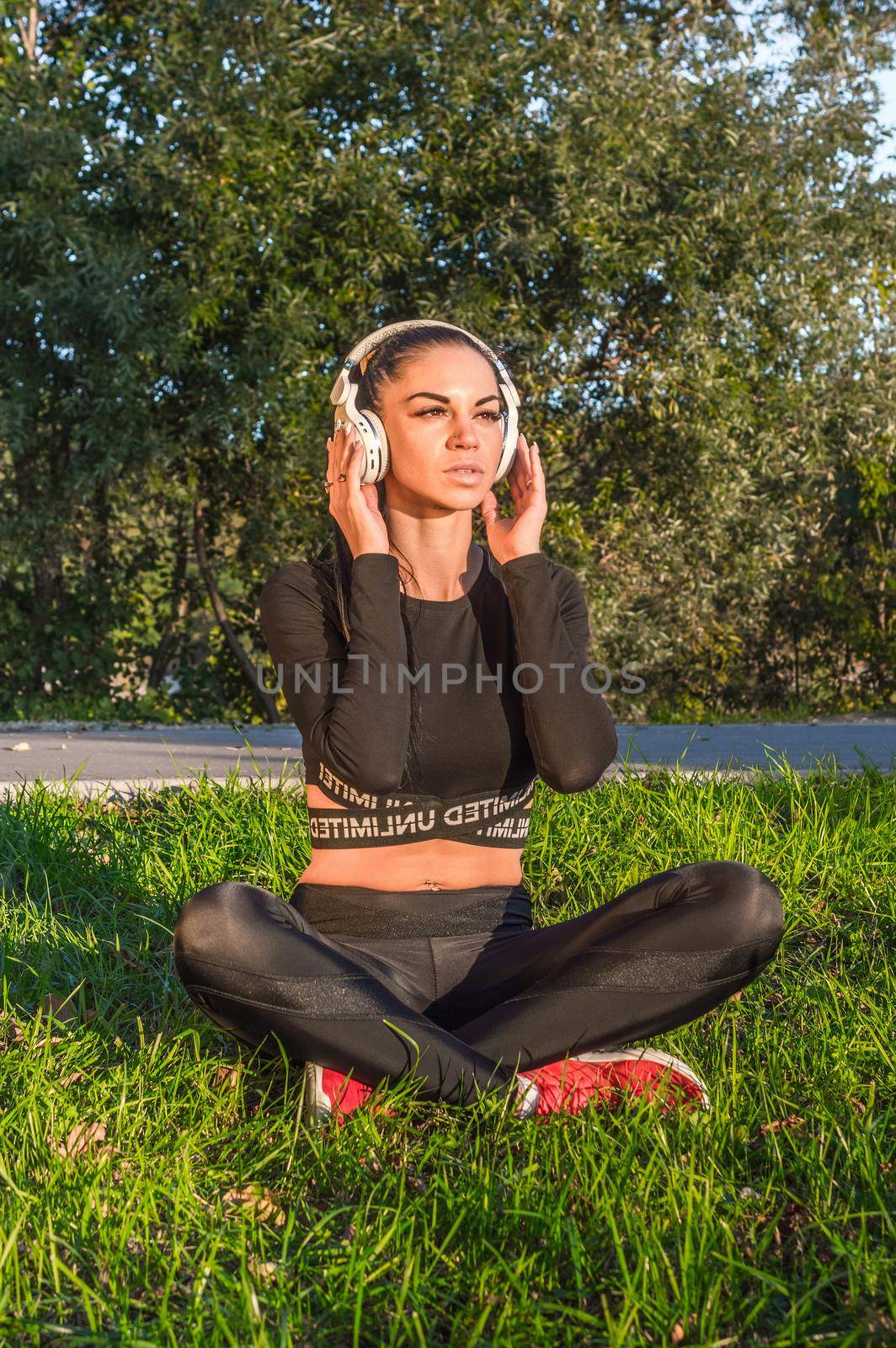 Fitness model lying and relaxing with headphones./Pretty young girl listening to music with headphones.
