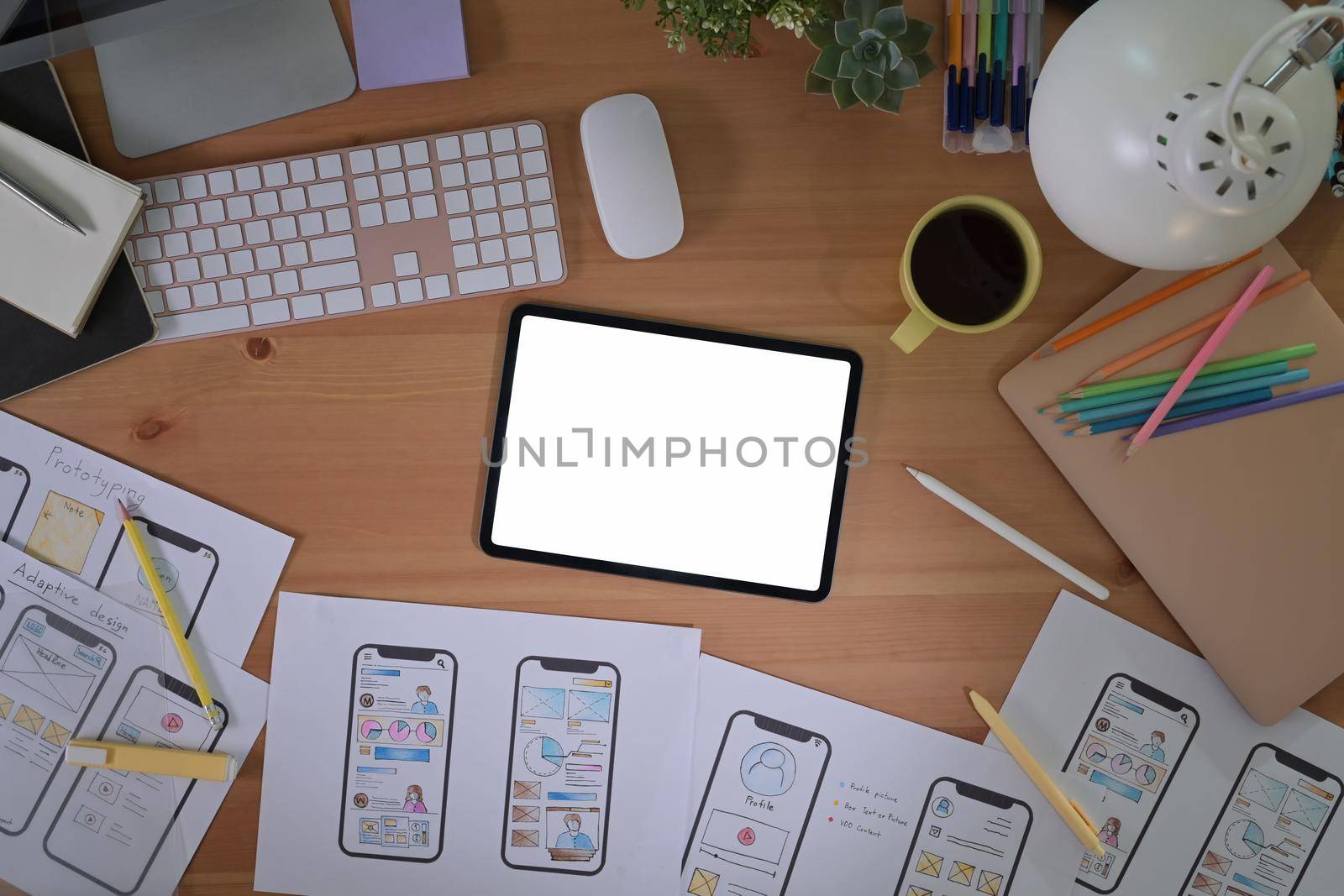 Top view digital tablet and mobile app wireframe sketches on wooden table.