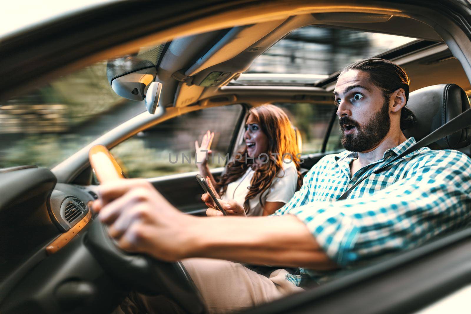 Couple in a car at sunset, with man driving fast and girl scared, screaming and crying.