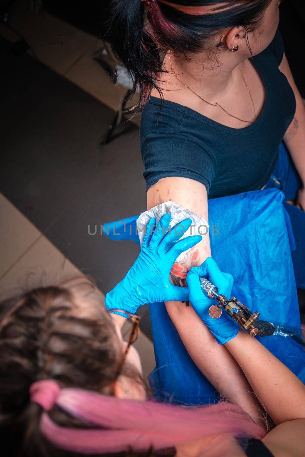 Professional tattooer demonstrates the process of getting tattoo in tattoo studio.