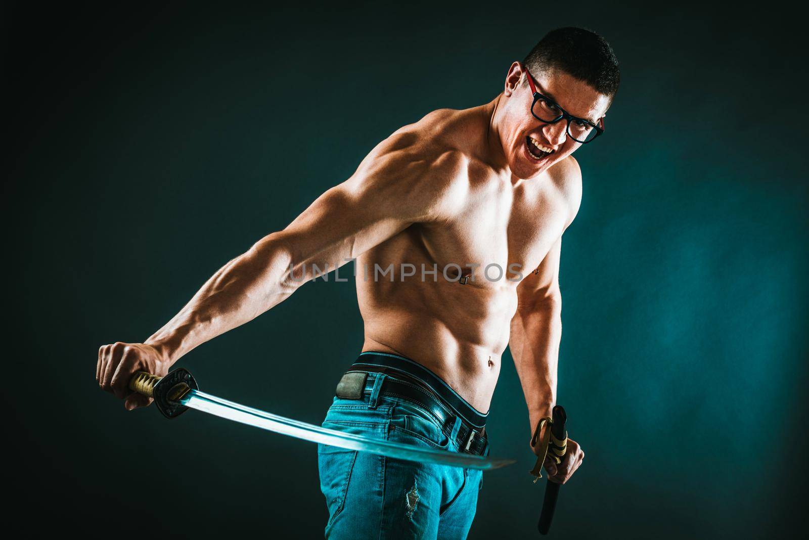 A perfect muscular man is performing exercise with katana sword.