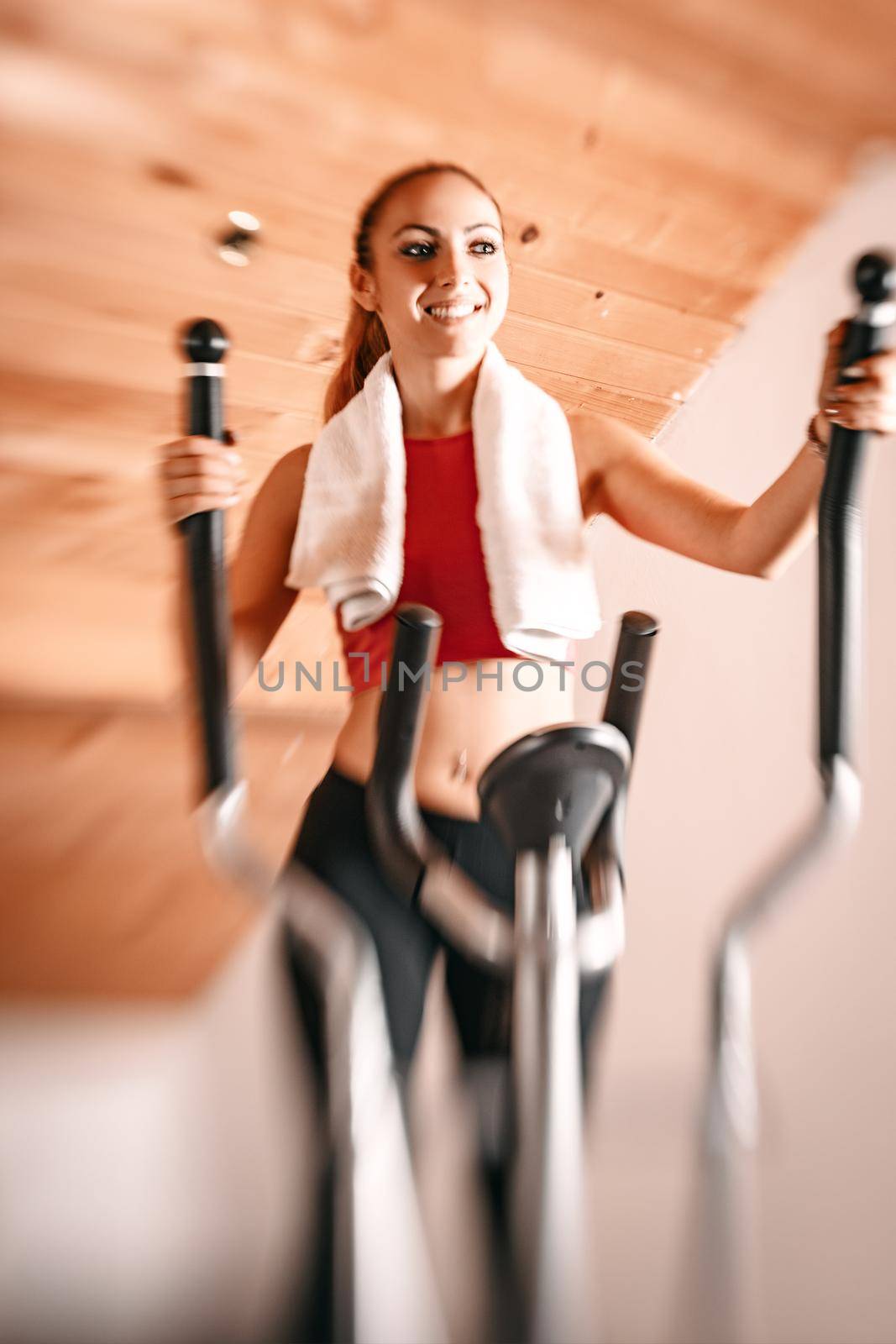 Beautiful young woman exercising on stepper at home.