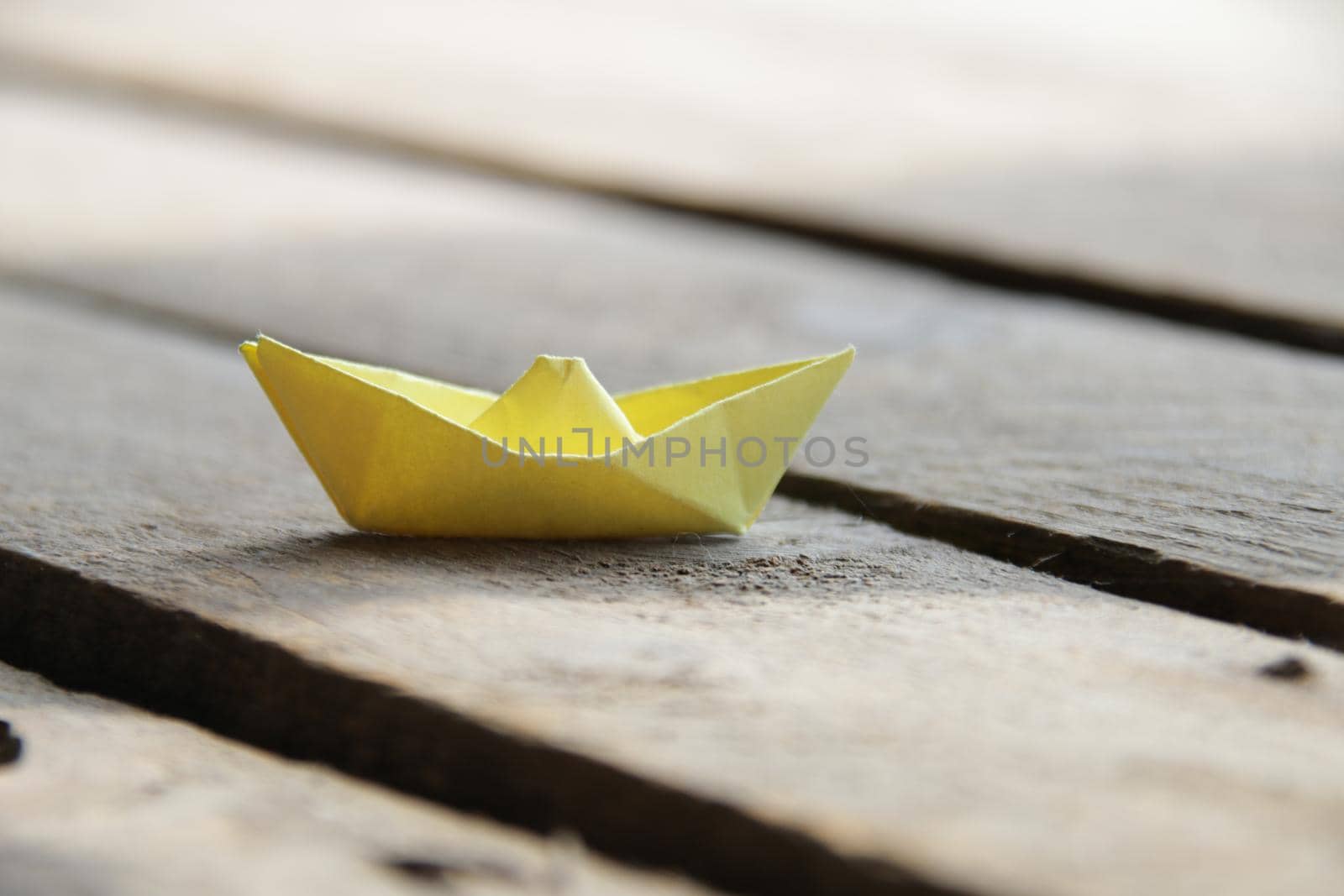 Yellow paper boat. Summer vacation creative idea.
