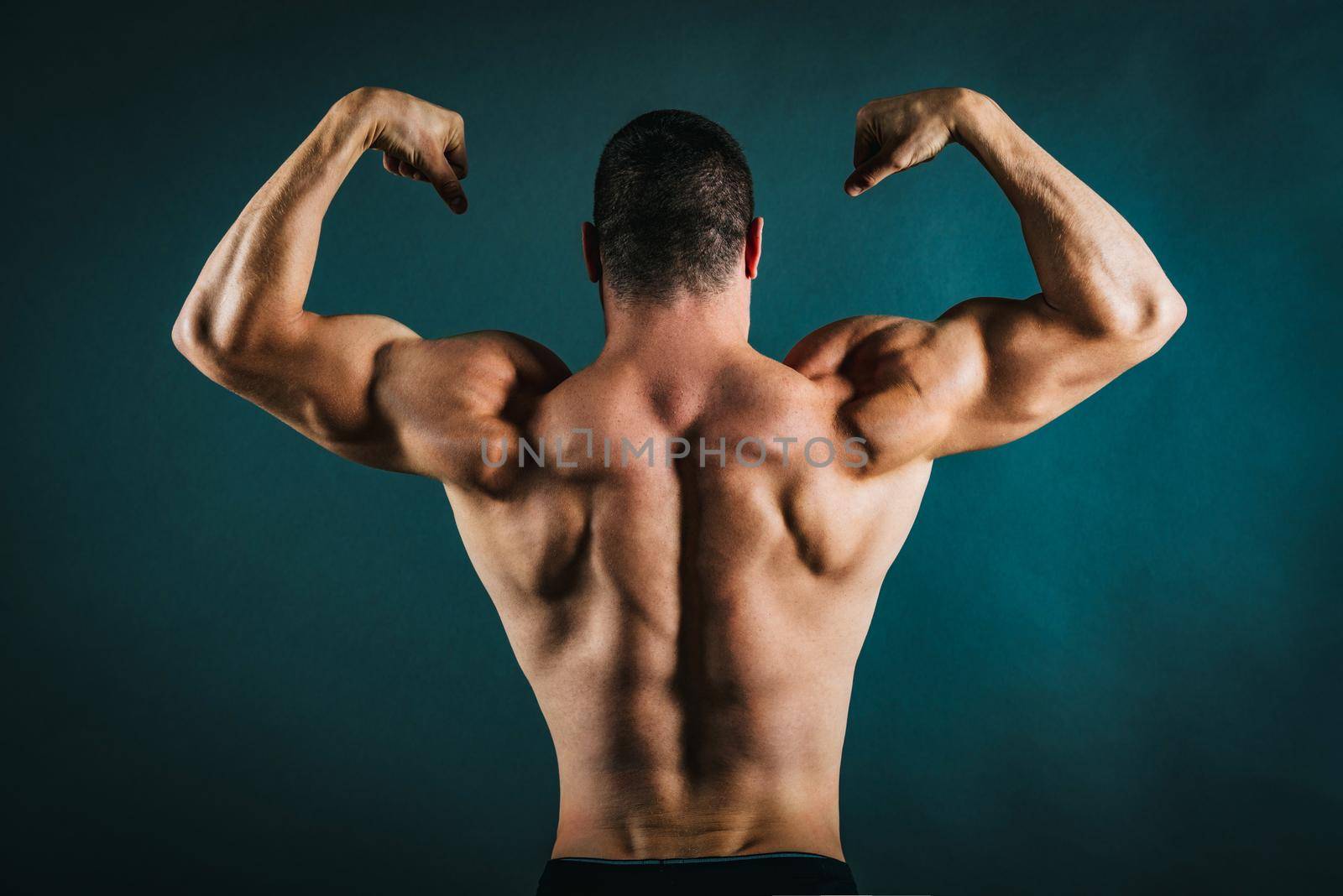 Rear view of a perfect muscular young man without a shirt.