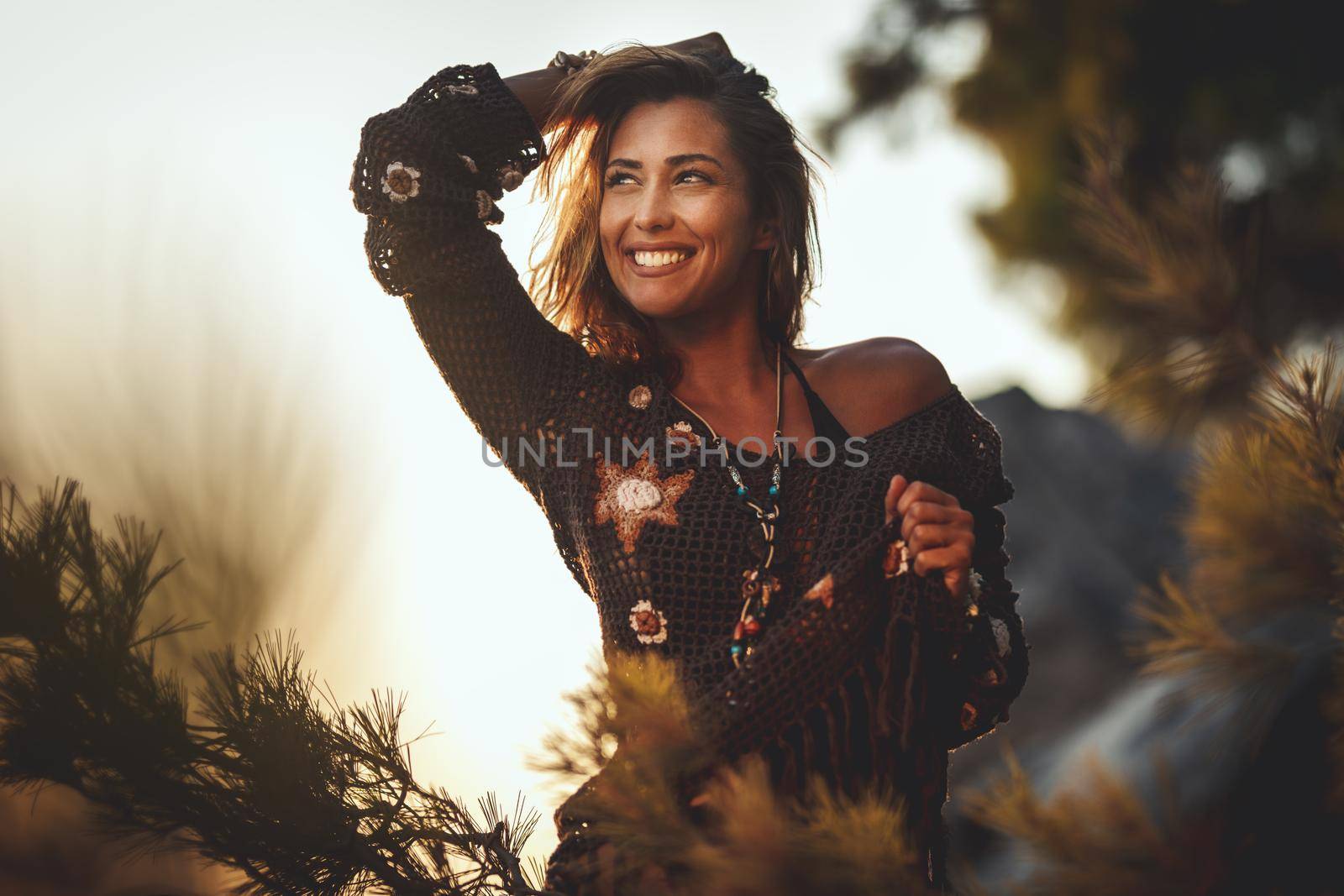 A beautiful young woman is having fun and relaxing on the beach at the sunset. 