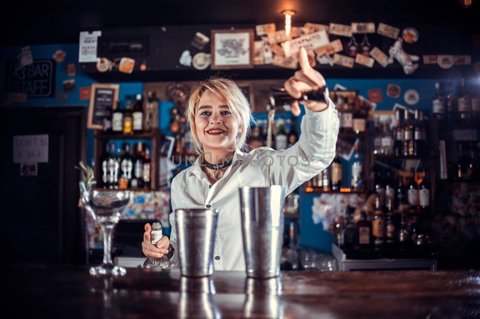 Girl bartender concocts a cocktail at the public house by Proff