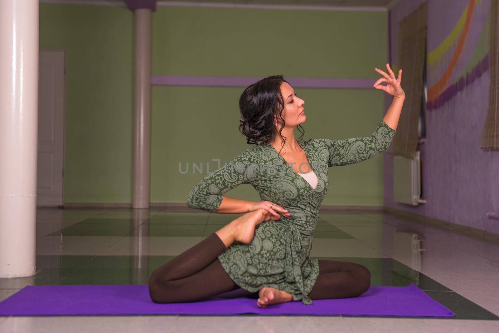 Fit girl performs yoga asana in a studio by Proff