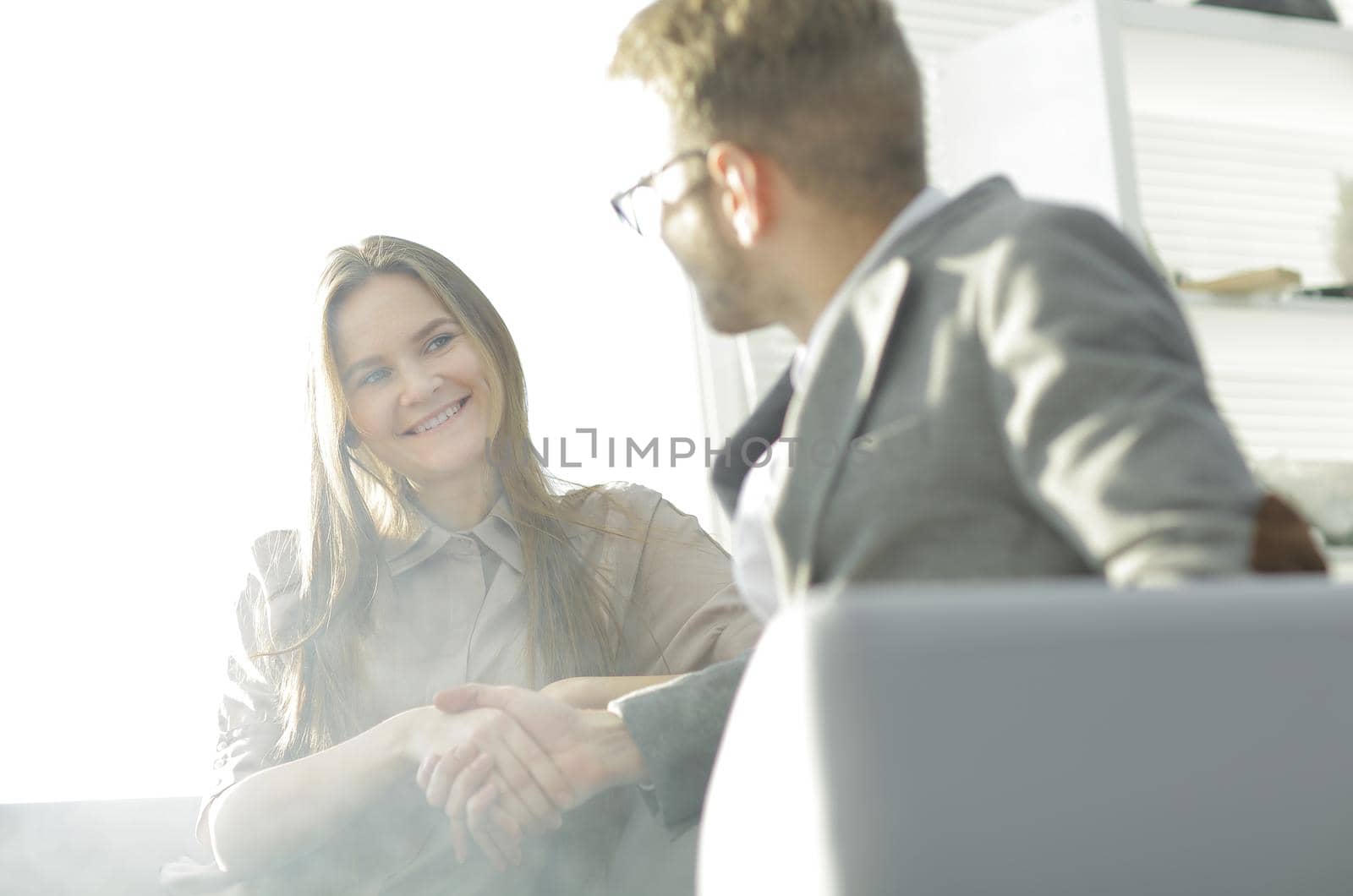 background image of a handshake of colleagues in the workplace.photo with copy space