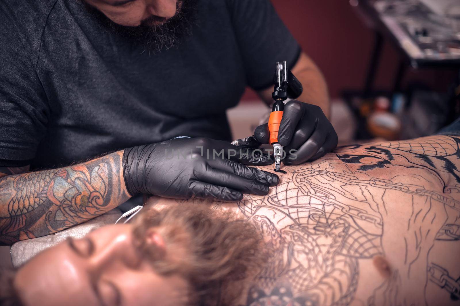Tattooer working on professional tattoo machine device in tattoo studio by Proff