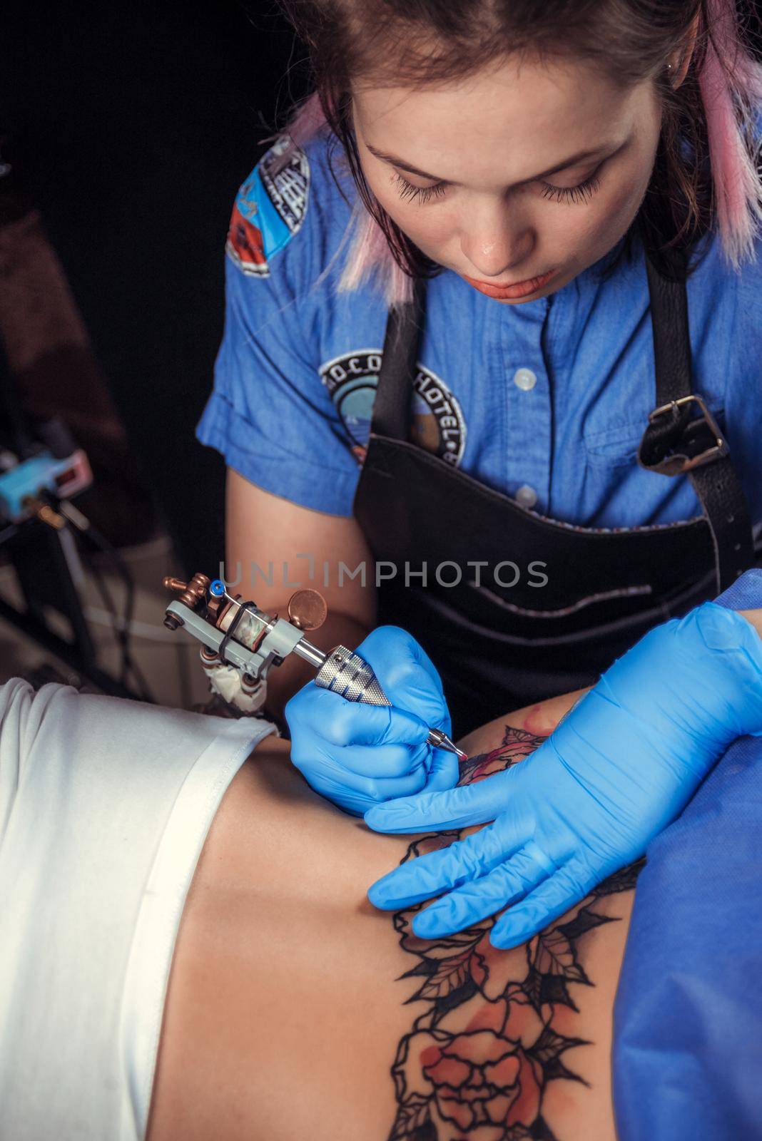 Master tattooist demonstrates the process of getting tattoo in tatoo salon by Proff
