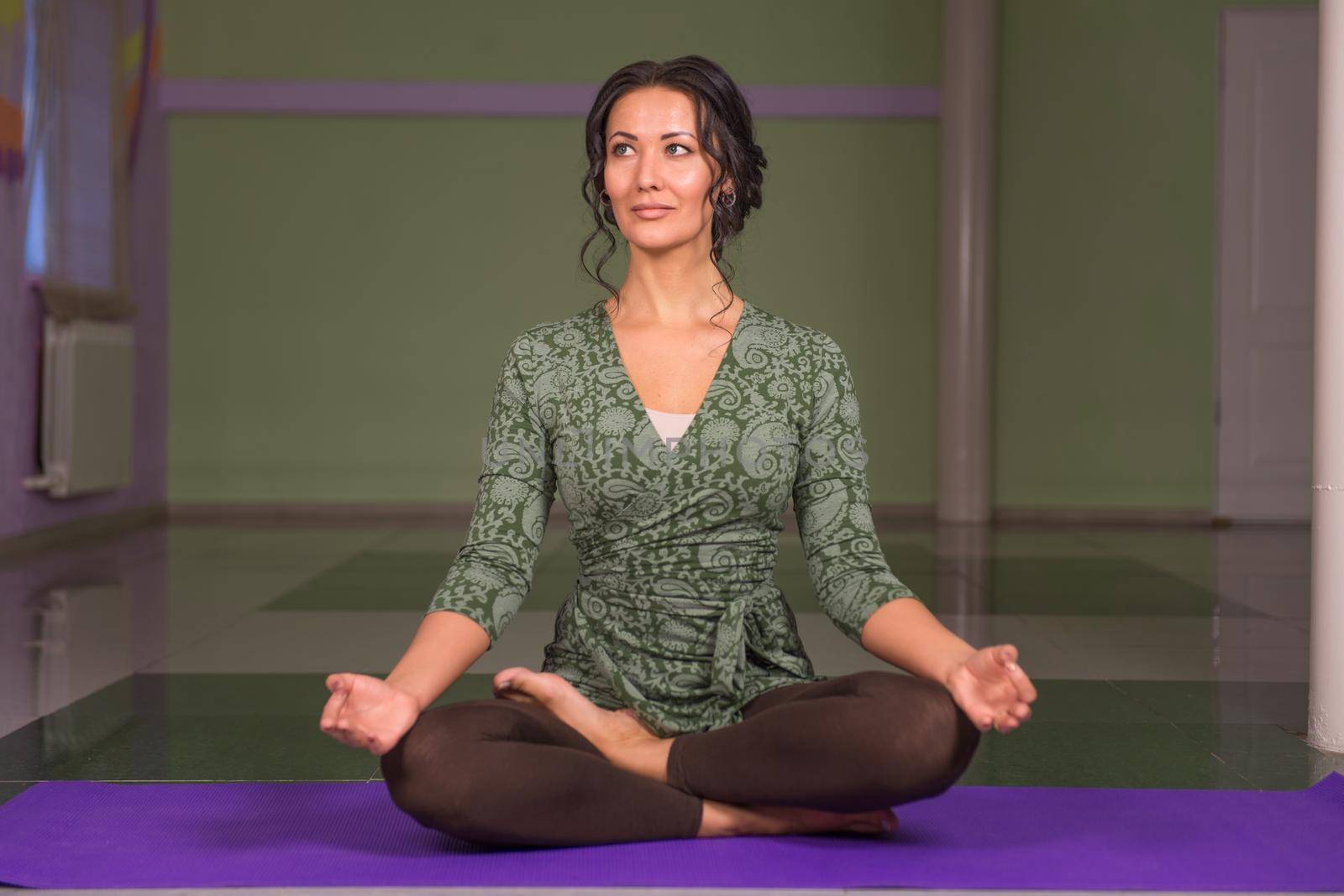 Woman shows yoga exercises ./Yoga trainee teaching yoga .