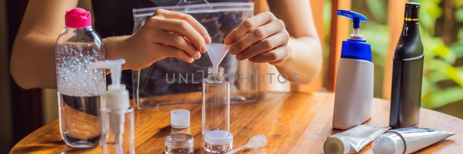 Travel kit for transporting cosmetics on an airplane. Cosmetics are ready to be poured into small bottles. A woman shifts cosmetics to take with her. BANNER, LONG FORMAT