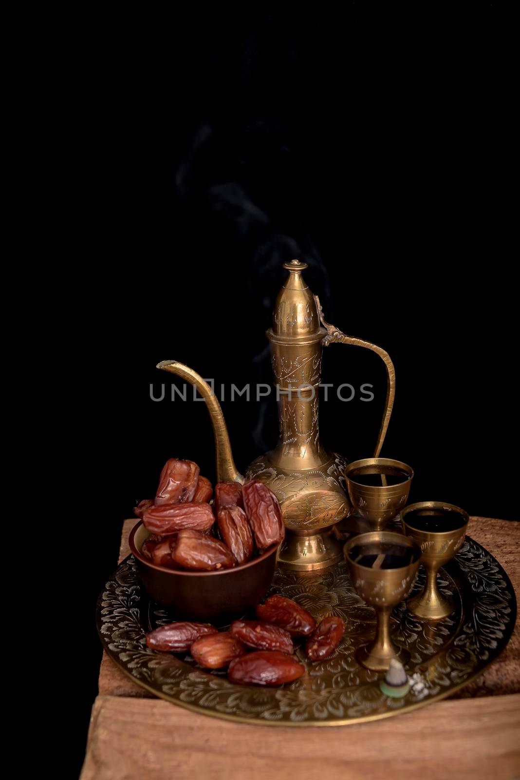 Ramadan concept. Dates closeup in the foreground. Ramadan Lantern on a wooden table. Textured black wall background