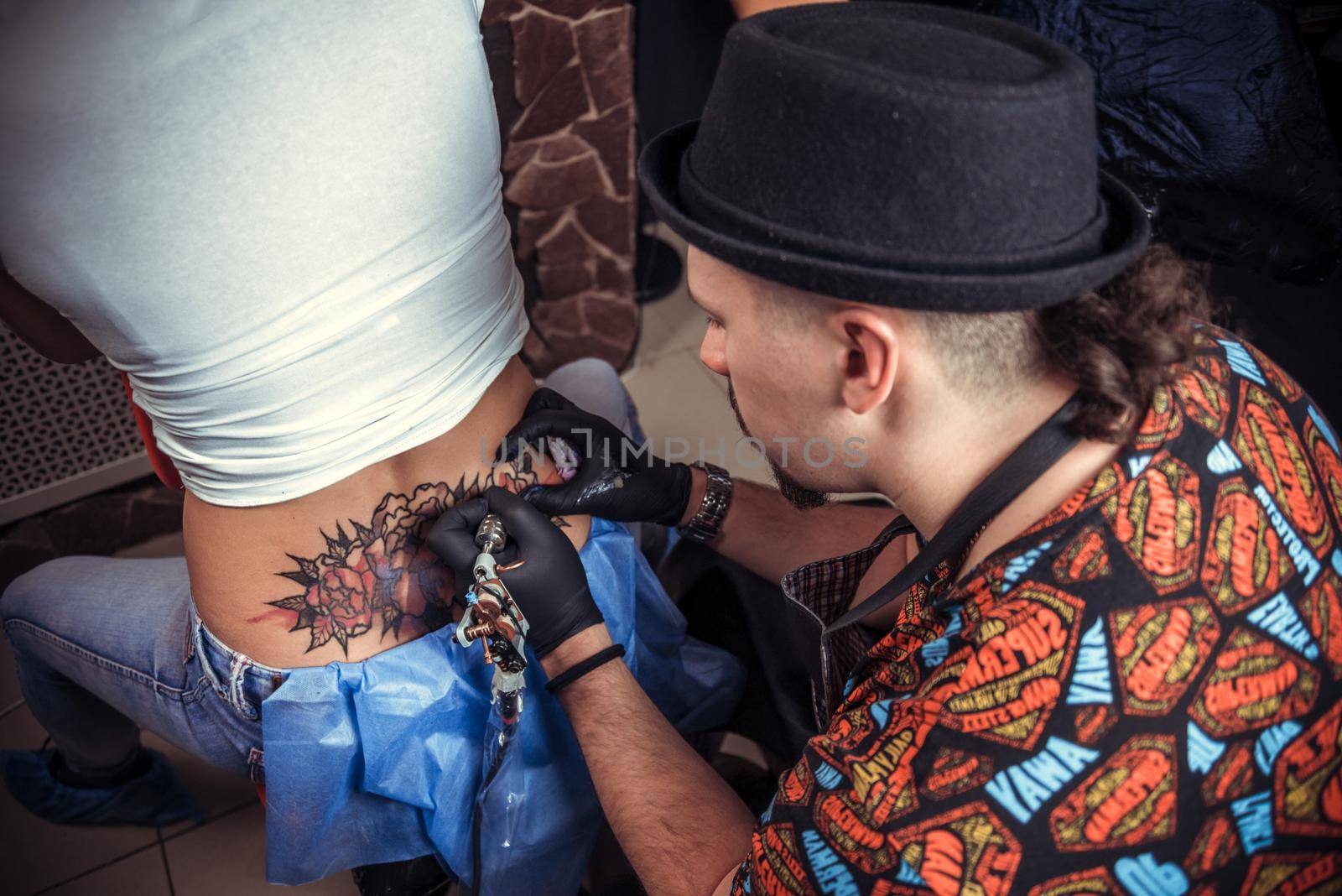 Master tattooist working tattooing in tattoo parlor by Proff