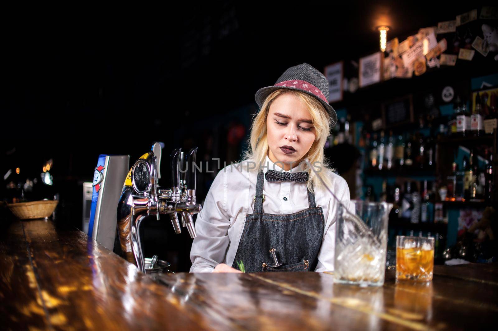Young girl tapster makes a show creating a cocktail in the bar