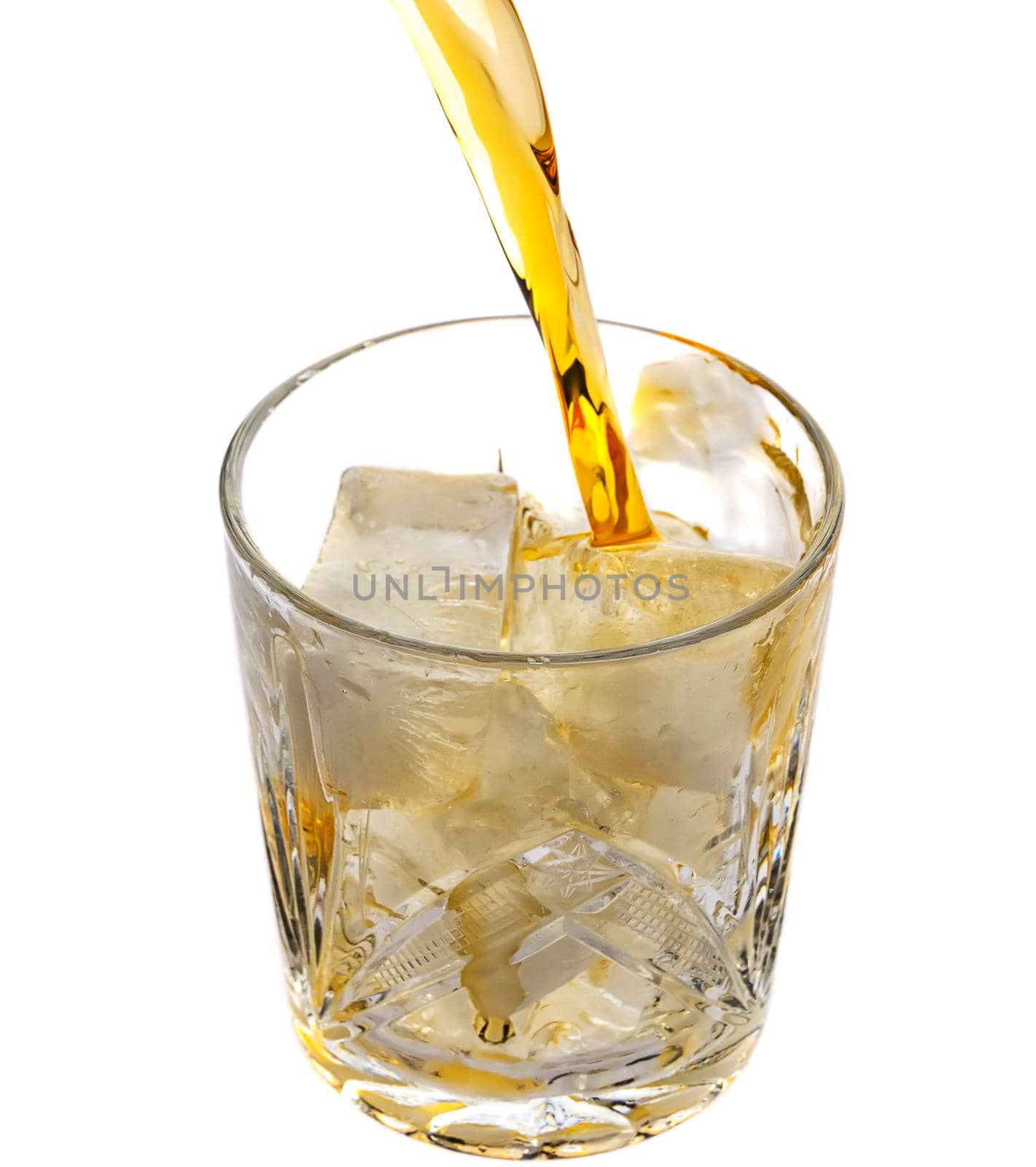 Pouring whiskey in an empty glass with ice.Top view