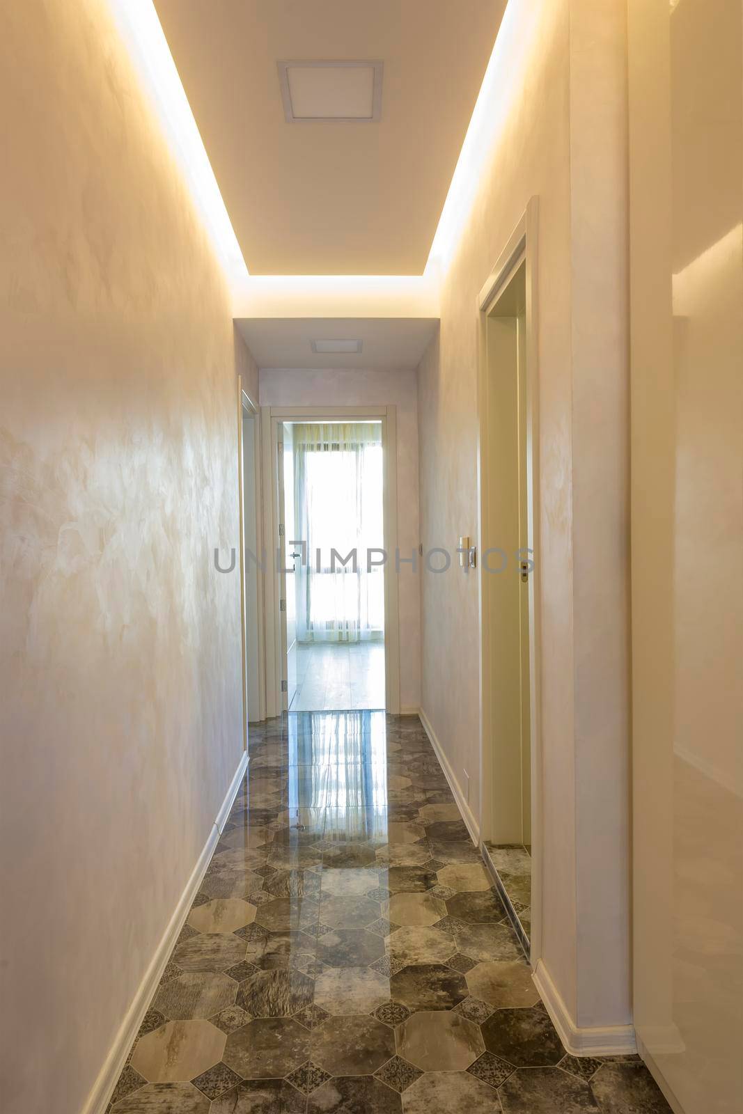 new home corridor with an open door at the end and ceramic tiles