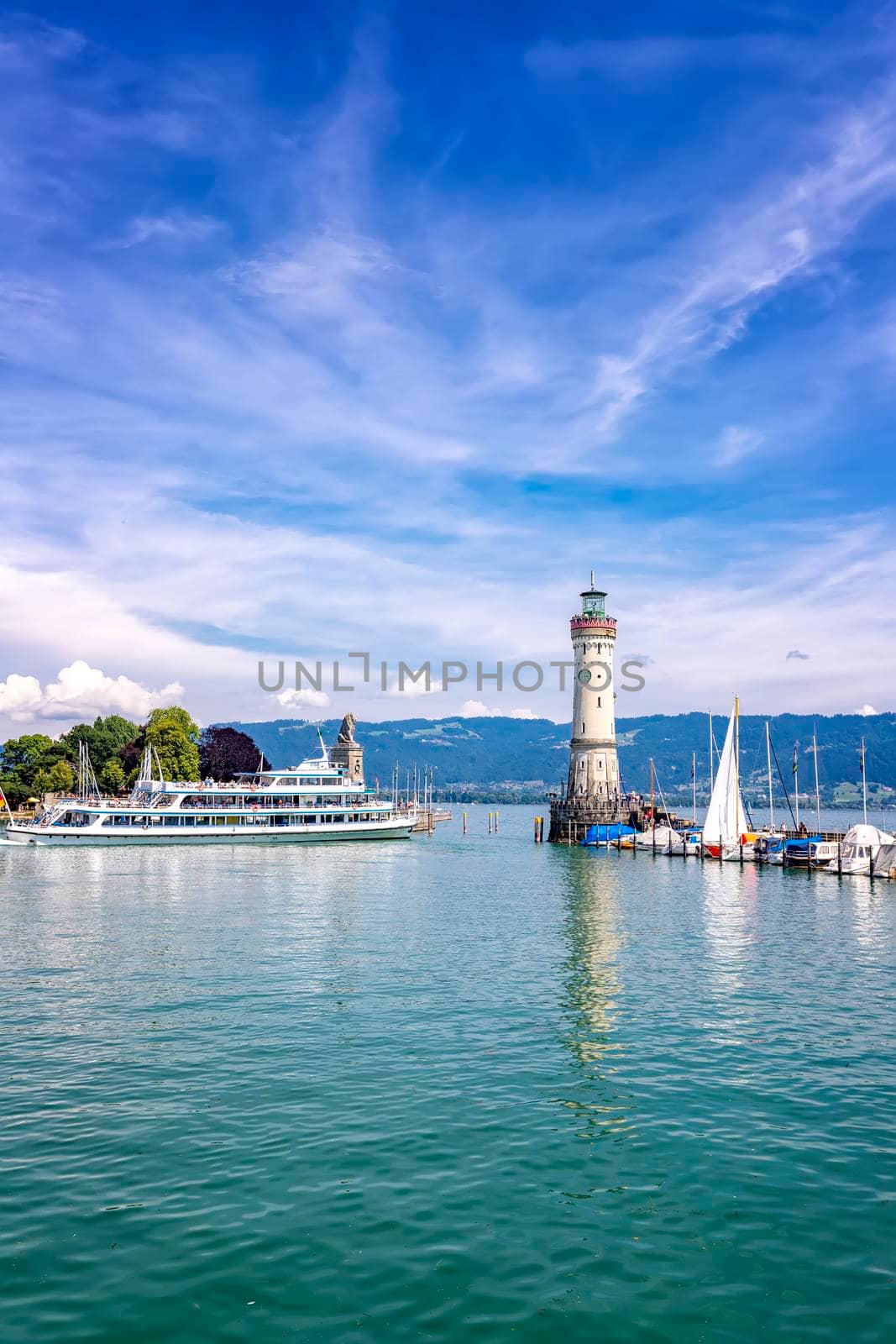 Lindau, Germany - July 21, 2019: Ship sails away from picturesque port town Lindau on Lake Constance.. Vertical view