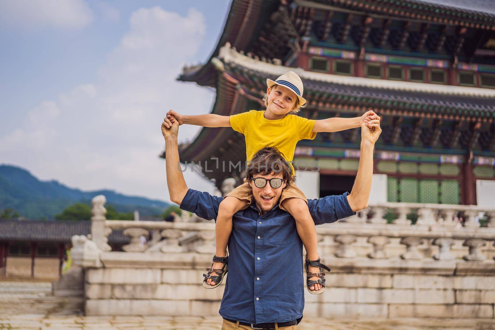 Dad and son tourists in Korea. Gyeongbokgung Palace grounds in Seoul, South Korea. Travel to Korea concept. Traveling with children concept by galitskaya