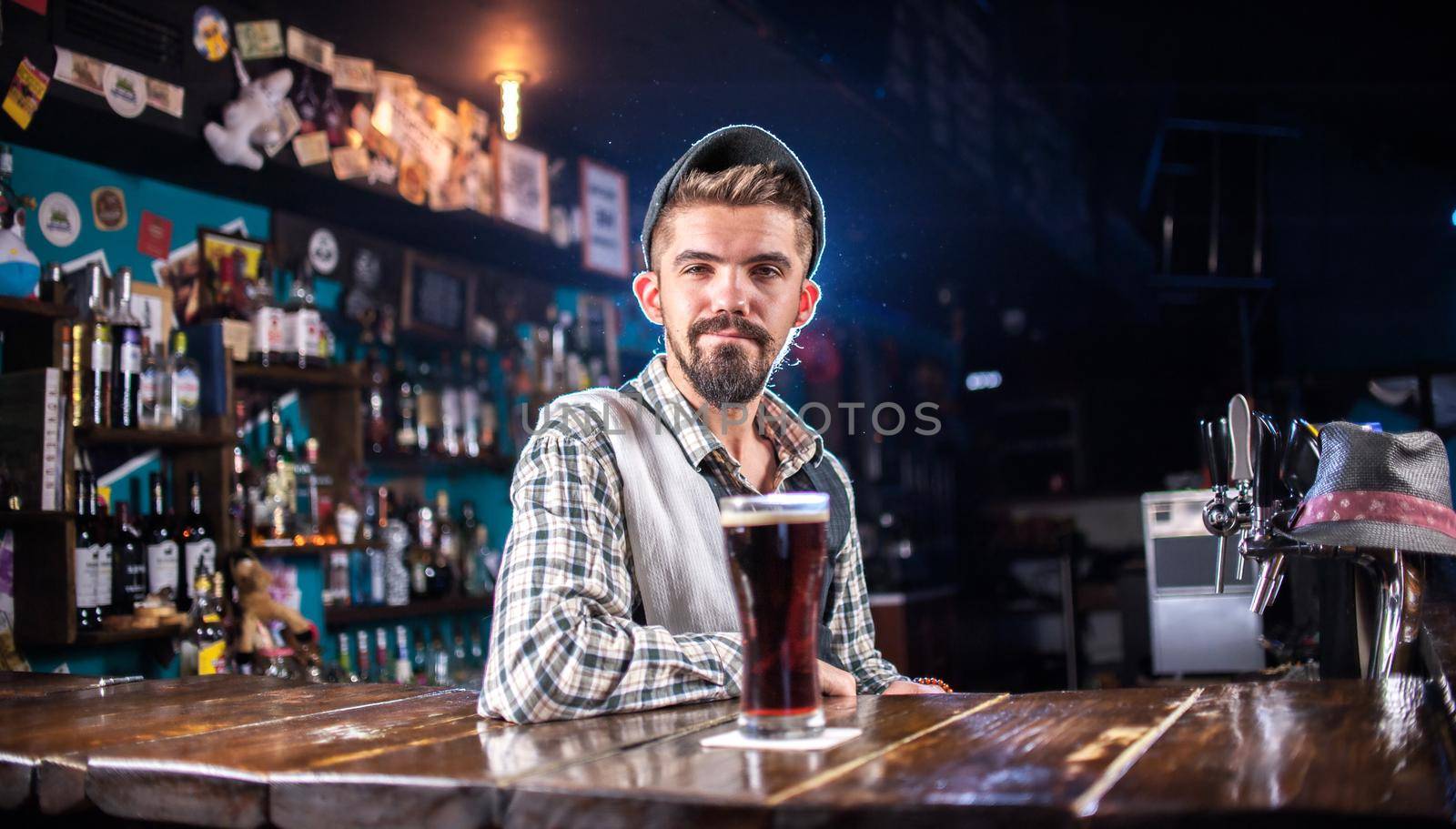 Charismatic barkeeper mixes a cocktail at the bar counter