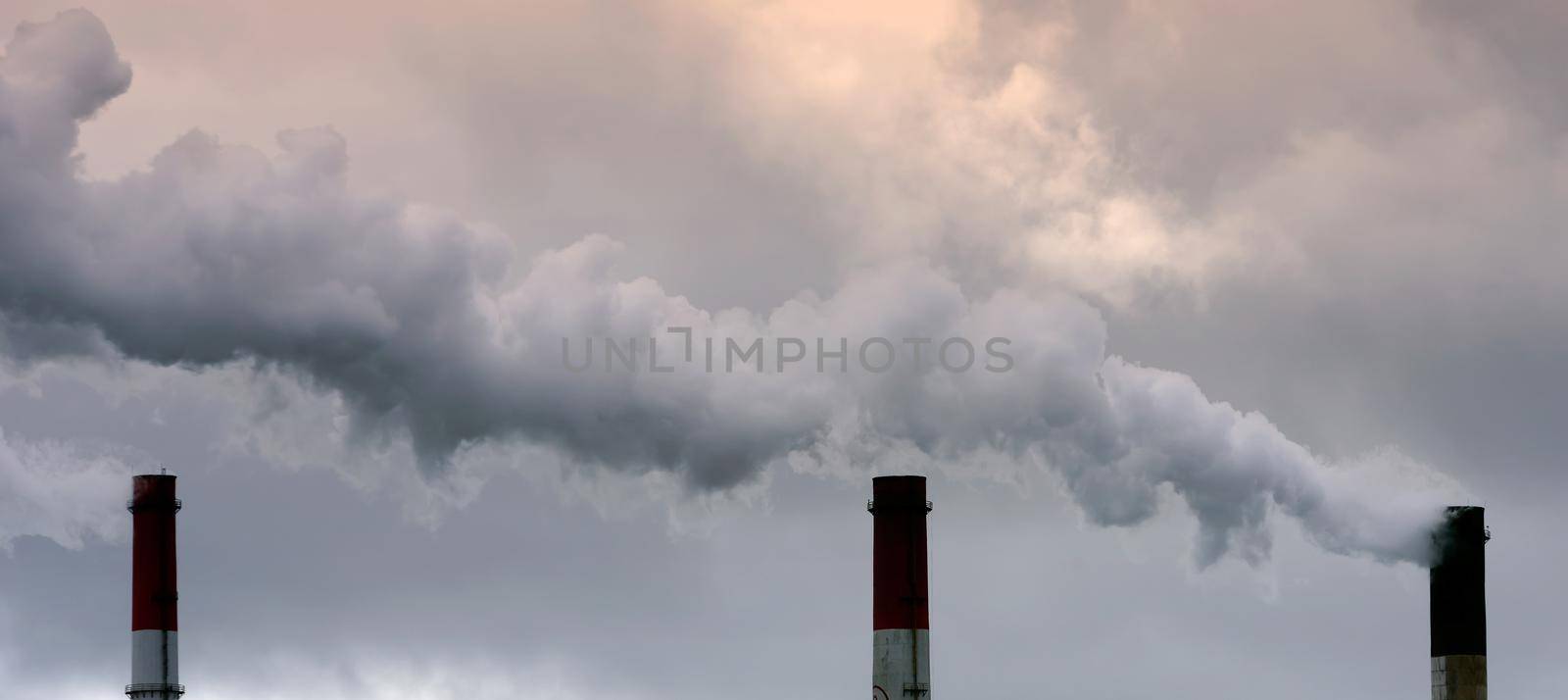 Air pollution from smoke coming from three factory chimneys. by Hil