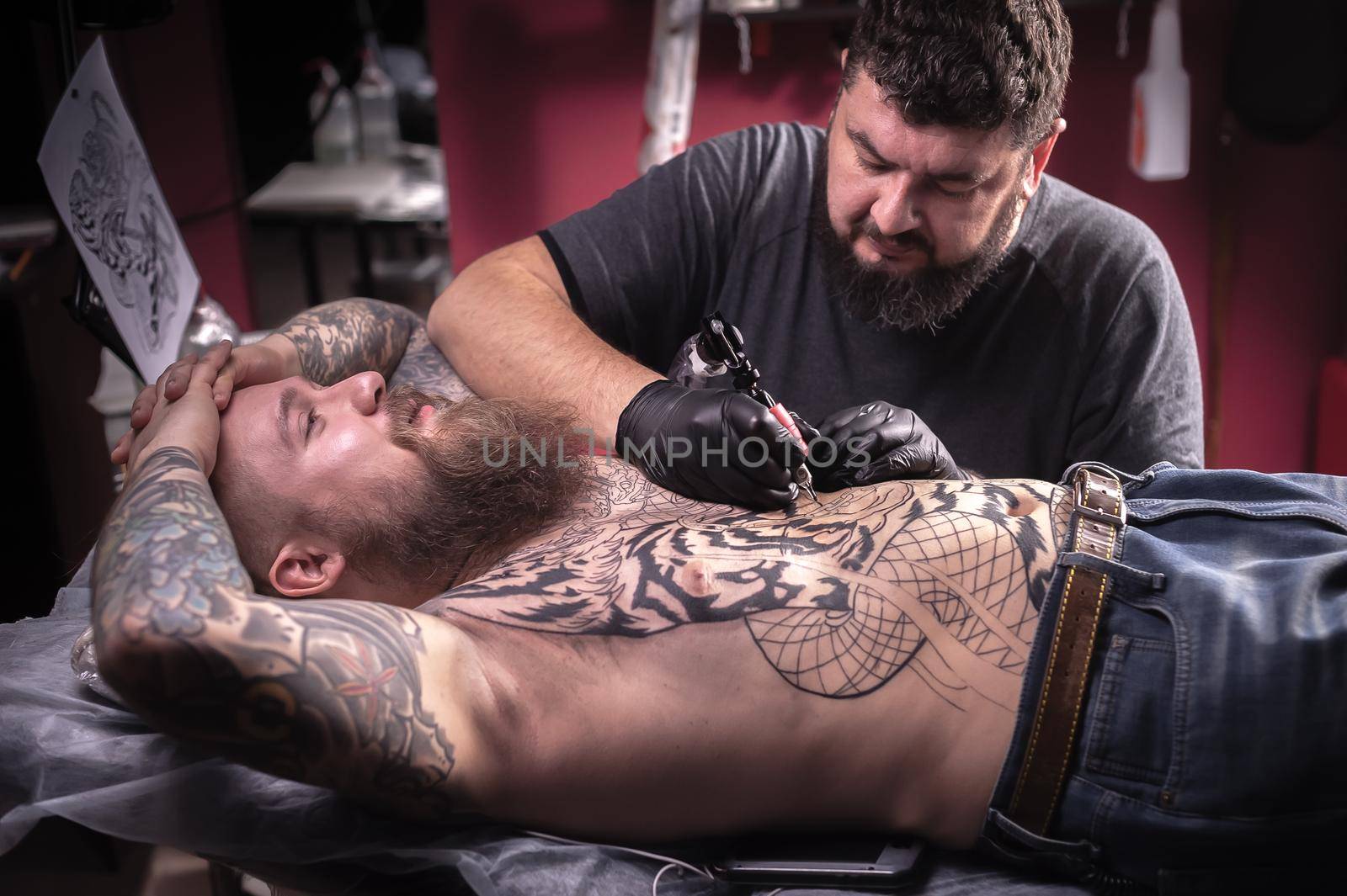 Tattoo specialist posing in tattoo studio.